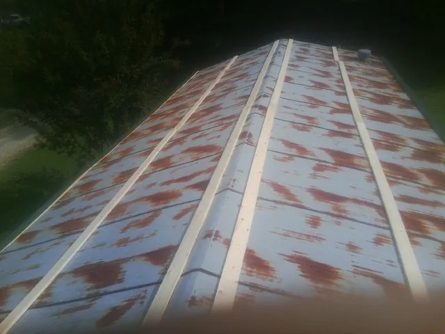 Rusted metal roof panels with new wood purlins before replacement — Storm Damage Roof Repair in Red Rock by Roofing Brothers